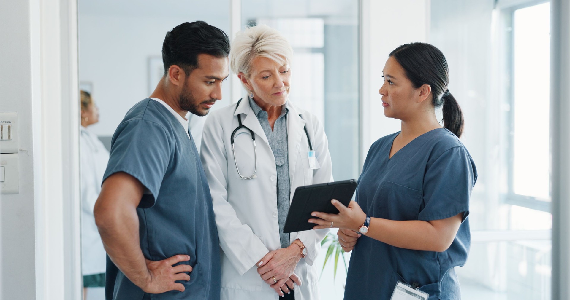 Doctor, tablet and nurse in meeting, research or planning surgery in teamwork or results at hospital. Group of medical or healthcare professionals with technology in team or schedule plan at clinic